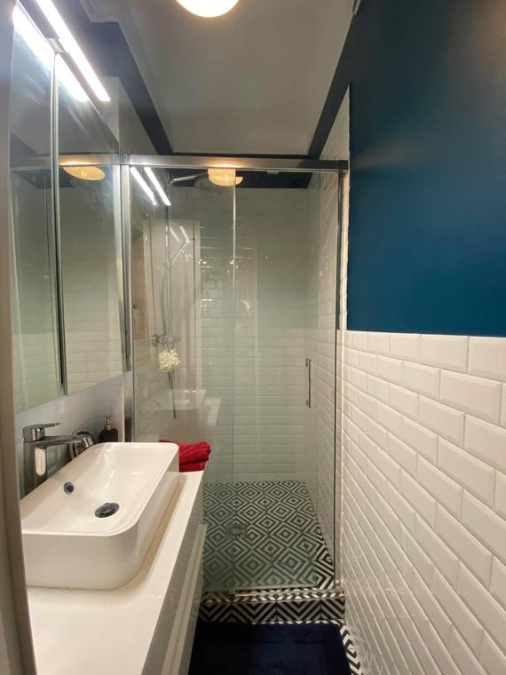 Salle de bains avec mur bleu canard, carrelage métro et douche