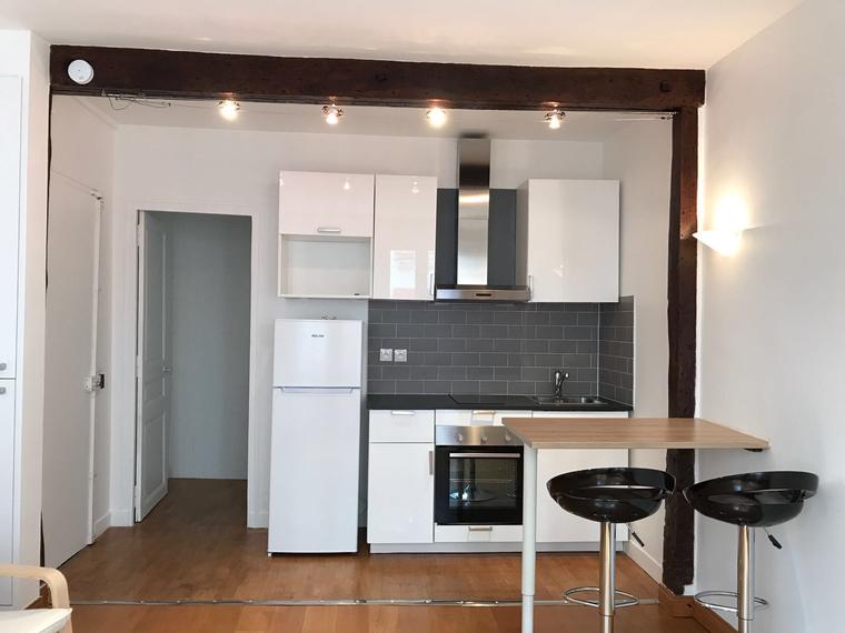 Cuisine ouverte avec crédence grise et parquet